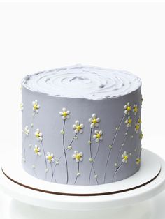 a cake with white frosting and yellow flowers on it