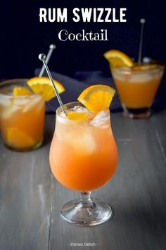 two glasses filled with orange juice and garnished with lemon wedges