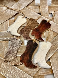 four pieces of animal fur hanging from strings on wood planks with white and brown strips