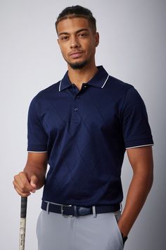 a man is holding a baseball bat and posing for a photo in front of a gray background