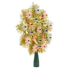 a green vase filled with lots of gold and white flowers on top of a table