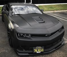 a black chevrolet camaro parked in a parking lot