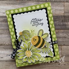 a close up of a card with a bee and flowers on the front, in green polka dots