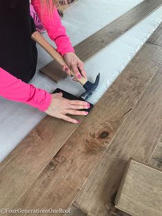 a woman in pink shirt laying on floor next to wooden planks