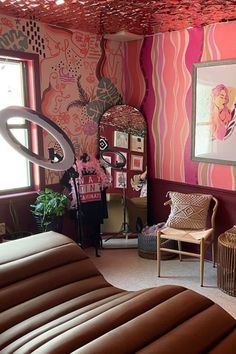 a living room decorated in pink and brown with zebra print on the walls, couches, chairs, rugs and mirrors