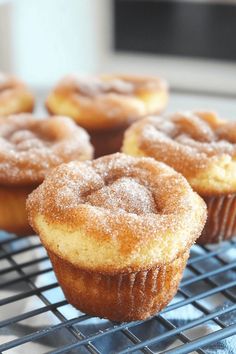 some sugared cupcakes sitting on a cooling rack