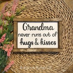 there is a sign that says grandma never runs out of hugs and kisses on it