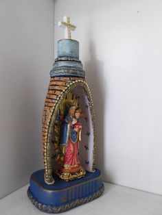 a statue of the virgin mary and child jesus with a cross on it's head