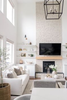 a living room filled with furniture and a flat screen tv mounted on the wall above a fireplace