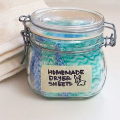 a glass jar filled with blue and green dyes next to a white dish towel