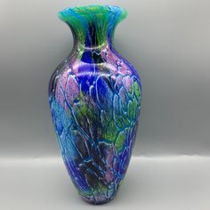 a blue and green vase sitting on top of a table