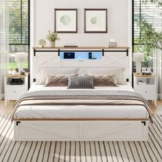 a white bed sitting in a bedroom next to two framed pictures on the wall above it