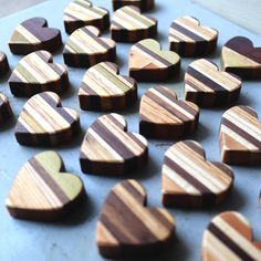 several wooden hearts are arranged on a blue surface with brown and white stripes in the middle