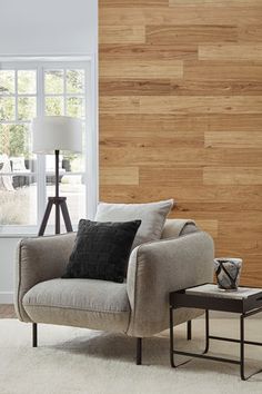 a living room with wood paneling on the wall and a chair in front of it