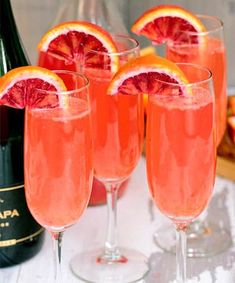 three glasses filled with pink wine and garnished with grapefruit