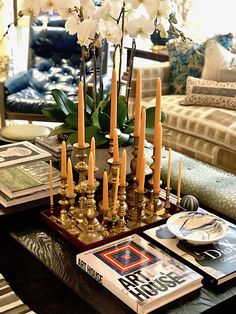 a coffee table with candles and books on it