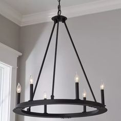 a chandelier hanging from the ceiling in a room with gray walls and white trim