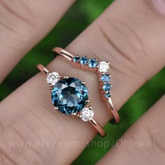 two rings with blue and white stones on each one, in the middle of their fingers