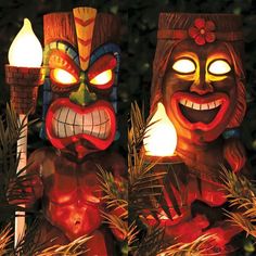 two tiki masks lit up in the night