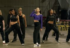 a group of young women standing next to each other on top of a dance floor