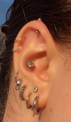 a close up of a person's ear with several piercings on it and one behind the ear