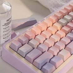 a computer keyboard sitting on top of a desk next to a bottle of water and a mouse