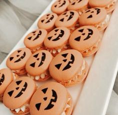 a white plate topped with cookies covered in frosting and jack - o'- lantern faces