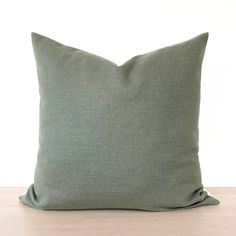 a green pillow sitting on top of a wooden table