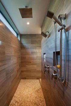 a walk in shower sitting next to a tiled floor and wall with wooden paneling