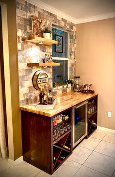 a kitchen with a wine rack and shelves filled with bottles on the counter, next to a tiled wall