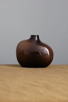 a brown vase sitting on top of a wooden table