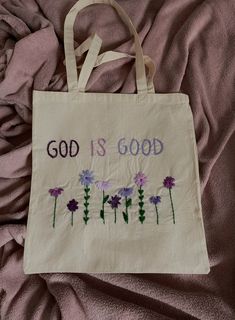 a bag that says god is good with purple flowers on the front and bottom side