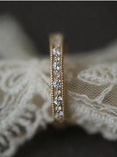 a close up of a wedding ring with diamonds