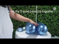 two blue balls are placed on top of a white table with the words, the 2 quad balloons together