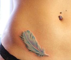 a woman's stomach with a blue feather tattoo on her belly and an ear piercing