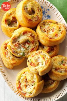 a white plate topped with mini pizzas on top of a green and white table cloth