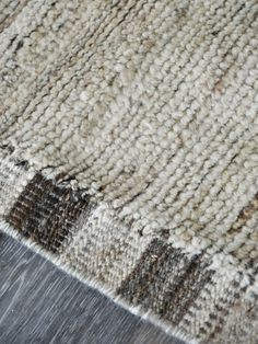 a close up view of a rug on the floor with wood and fabric textured