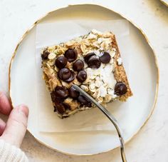 a person is eating granola bars on a plate