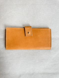 Introducing our custom line of leather handbags and accessories! Ethically made exclusively for Green Roost in Ethiopia and only available here! This is a limited edition collection, so snag yours before they're gone forever! This luxurious leather wallet will bring a timelessly classic look to your style. Crafted with quality Ethiopian leather & precision stitching, it strikes the perfect balance between elegance & durability. Its slim silhouette ensures convenience & its subtle embossed logo a Daily Use Light Brown Leather Wallet, Everyday Leather Wallet With Interior Card Slots, Light Brown Leather Wallet For Everyday Use, Brown Bifold Clutch For Everyday Use, Brown Bifold Clutch, Brown Vegetable Tanned Leather Wallets For Everyday Use, Brown Vegetable Tanned Leather Wallet For Everyday Use, Brown Vegetable-tanned Leather Wallets For Everyday Use, Brown Soft Leather Wallet For Everyday Use