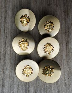 four brass knobs with ornate designs on them