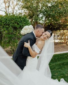 a bride and groom embracing each other in front of the camera on their wedding day