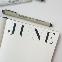 an open notebook with the word june written on it next to some markers and pens