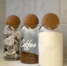 three glass jars filled with different types of coffee beans