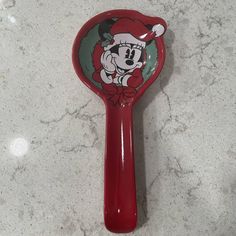 a red mickey mouse hair brush sitting on top of a counter