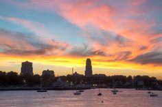 boats are floating in the water at sunset