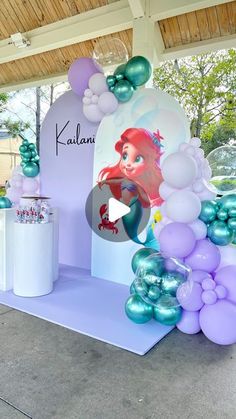 the little mermaid balloon arch is set up with balloons and streamers to welcome guests