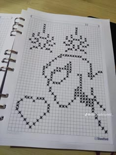 a cross stitch pattern on top of a notebook