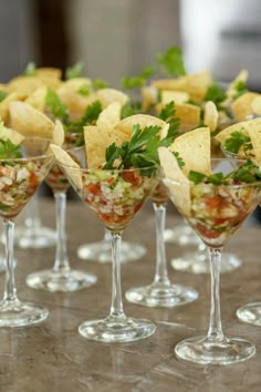 several martini glasses filled with different types of food and garnished with cilantro