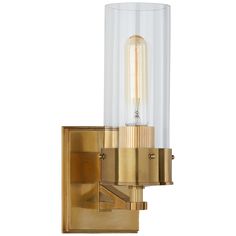 a wall light with a clear glass cylinder on the front and gold trim around it