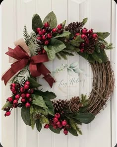 a wreath with red berries, pine cones and greenery is hung on the front door